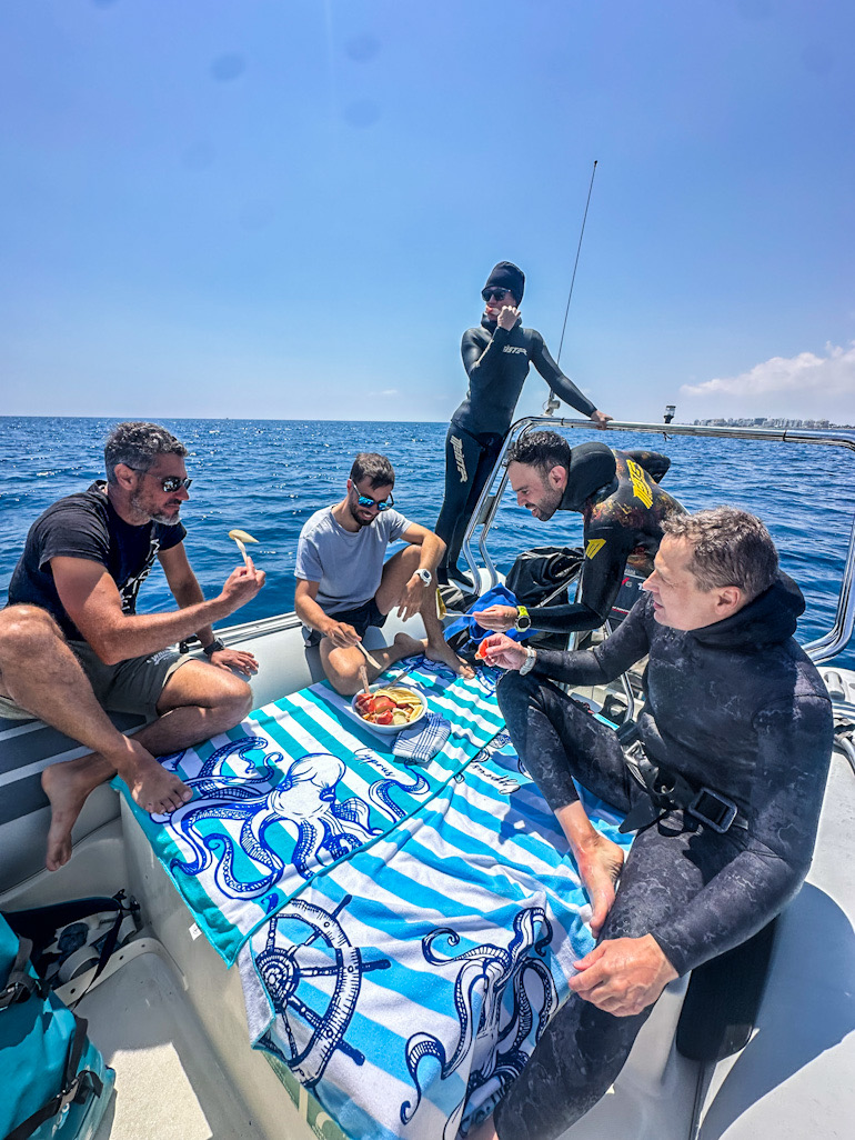 Group of freedivers sharing a meal on the boat between dive sites