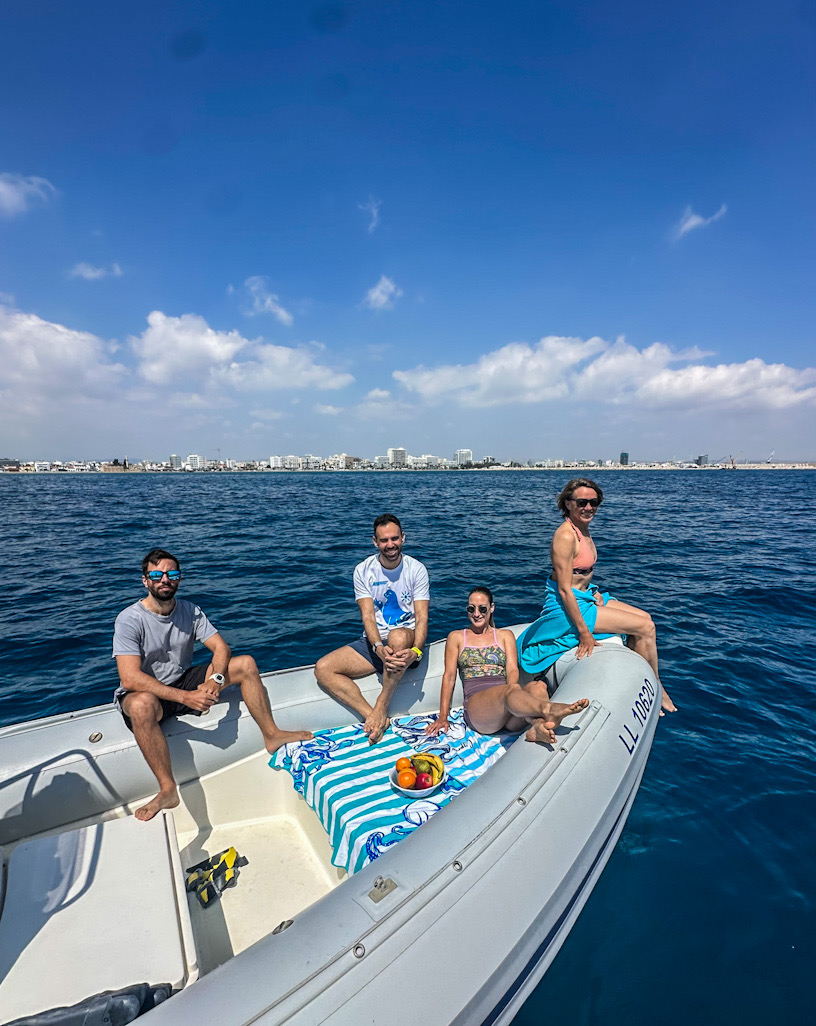 Group on the boat with Larnaca skyline behind, ready for the Blue & Rust trip