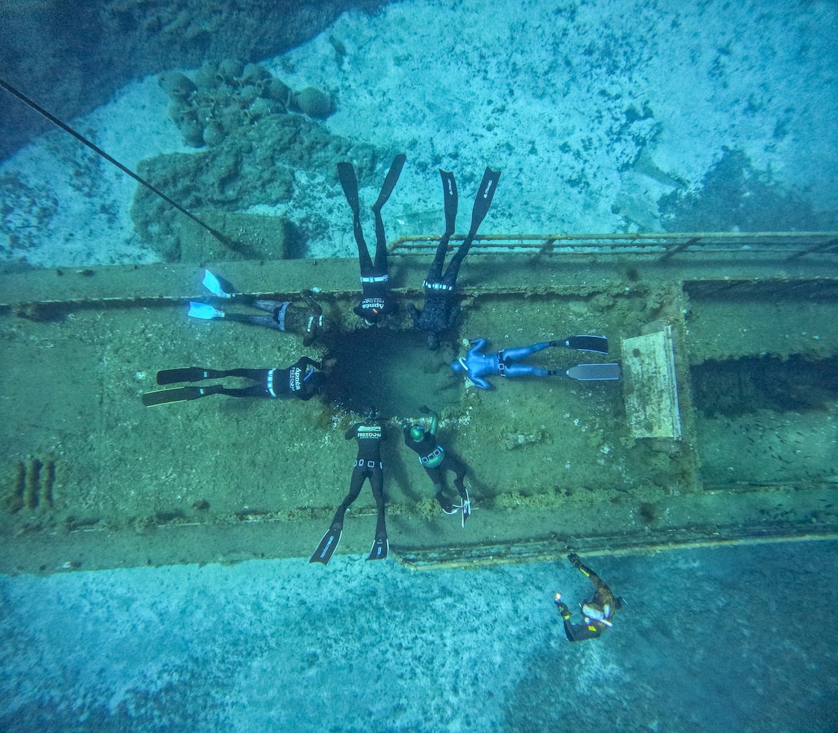 Top-down view of freedivers around a Mediterranean shipwreck off Larnaca